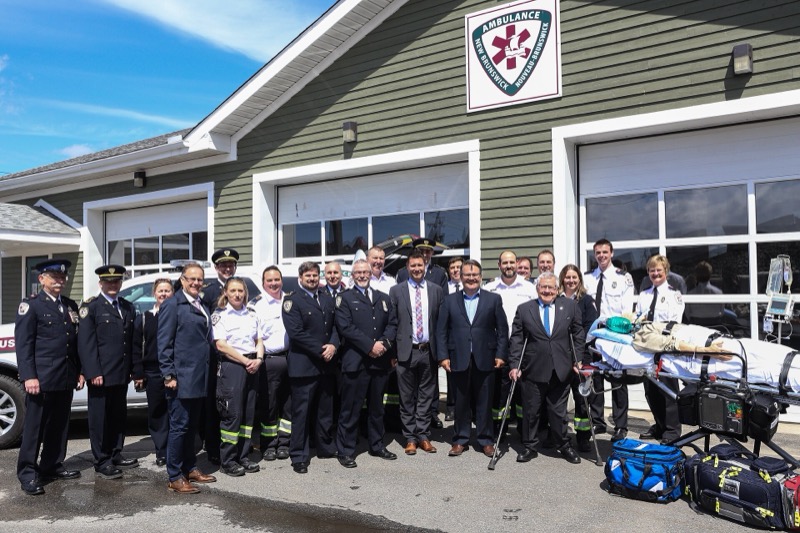Paramedics in uniform lined up in front of an Ambulance New Brunswick station, 2017
